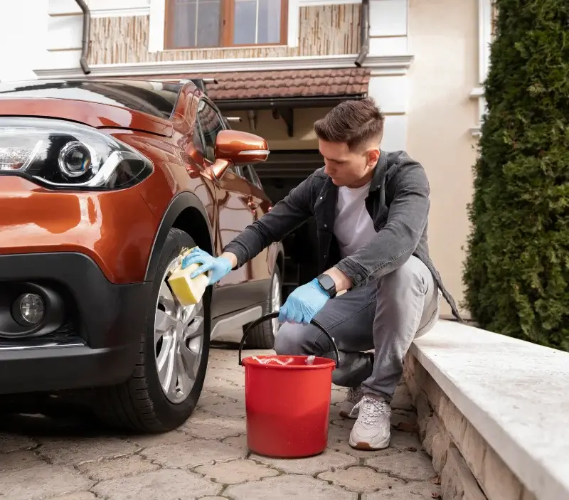 Lavage auto à domicile Saint-Jean-de-Savigny : professionnel intervenant sur un véhicule
